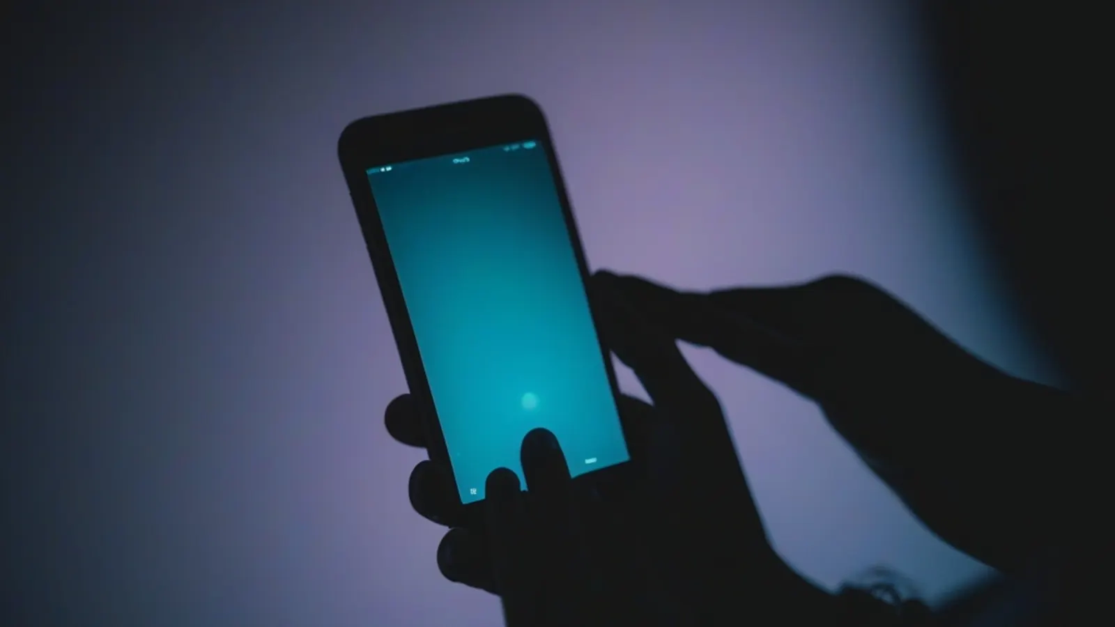 Uno smartphone con un'interfaccia di chat generica in una stanza in penombra, a simboleggiare un dialogo privato con un'intelligenza artificiale